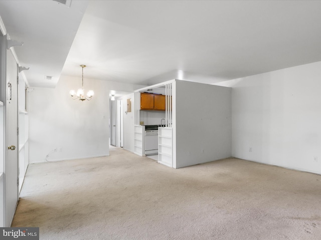 unfurnished living room with a chandelier, light carpet, and a sink
