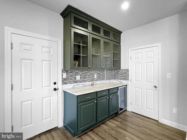 77 Iris Way, Charles Town, WV 25414 - kitchen featuring green cabinets, wood finished floors, tasteful backsplash, and glass insert cabinets