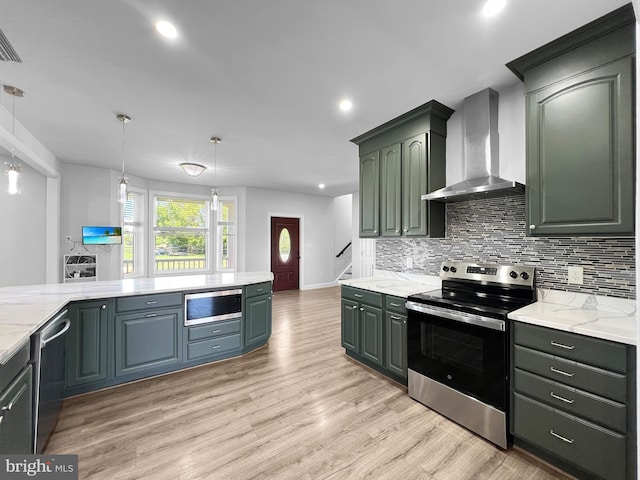 77 Iris Way, Charles Town, WV 25414 - kitchen with stainless steel appliances, wall chimney range hood, backsplash, light wood-style floors, and recessed lighting