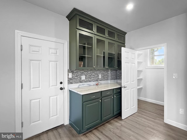 77 Iris Way, Charles Town, WV 25414 - kitchen featuring green cabinetry, decorative backsplash, light wood-style floors, and baseboards