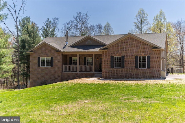 single story home with covered porch, a front lawn, and brick siding