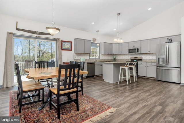 dining room with recessed lighting, lofted ceiling, and dark wood-type flooring