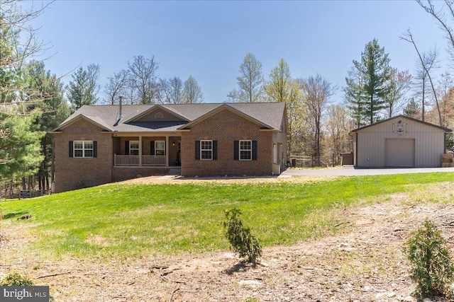 ranch-style home featuring an outdoor structure, a garage, covered porch, a front yard, and brick siding