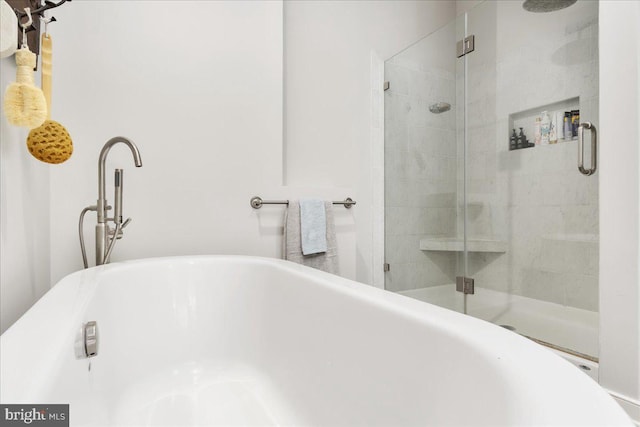 bathroom with a freestanding tub and a shower stall