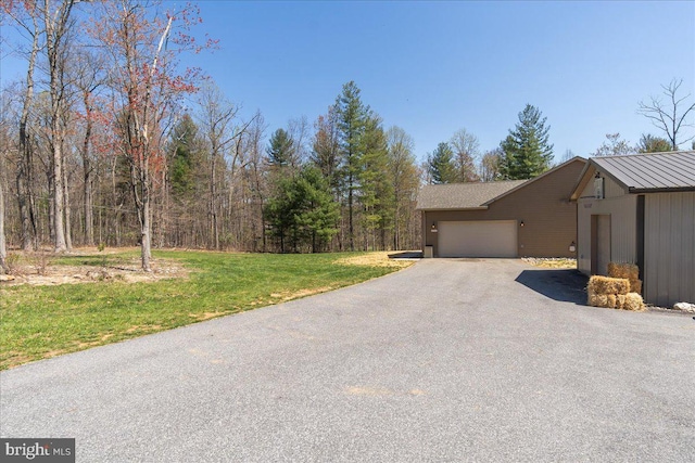 view of side of property with a lawn, a garage, and driveway