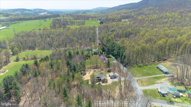 birds eye view of property featuring a mountain view and a wooded view