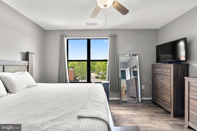 bedroom featuring wood finished floors, baseboards, and a ceiling fan