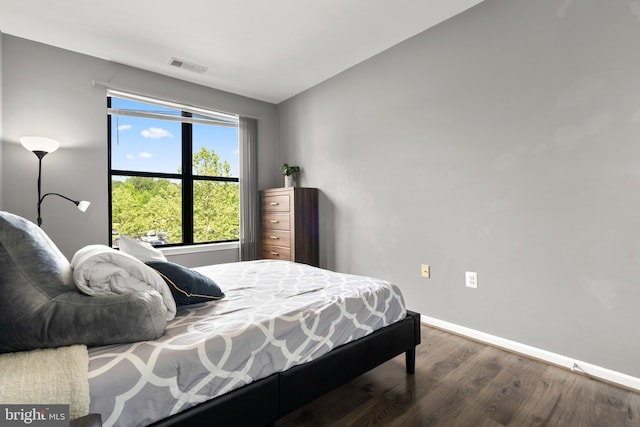 bedroom featuring wood finished floors, baseboards, and vaulted ceiling