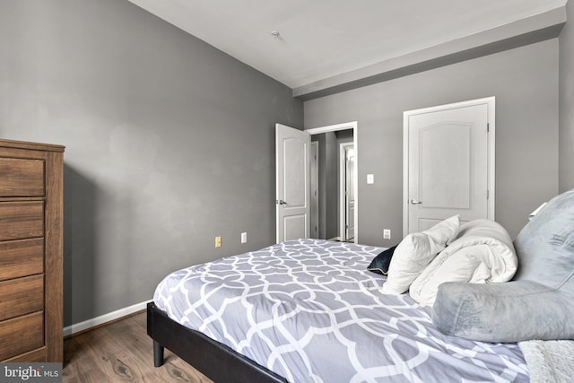 bedroom with dark wood-style flooring