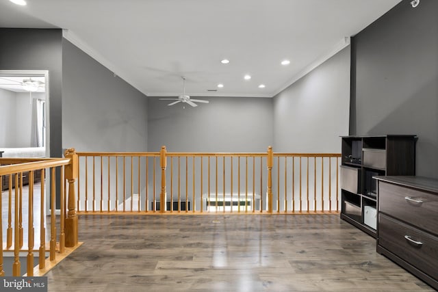 hallway featuring crown molding, wood finished floors, and recessed lighting