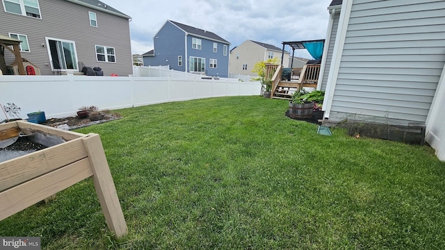 view of yard featuring fence, a wooden deck, and a residential view