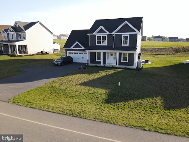 1011 Southwood Dr, Shippensburg, PA 17257 - view of front of property featuring asphalt driveway, covered porch, an attached garage, and a front lawn