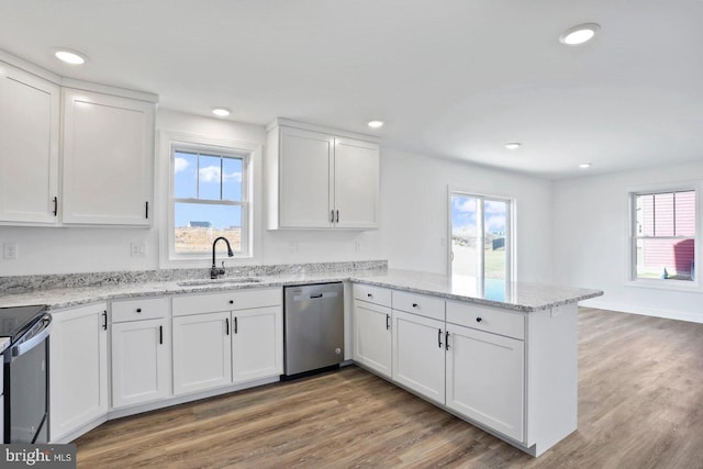 1011 Southwood Dr, Shippensburg, PA 17257 - kitchen featuring dishwasher, a sink, electric range, a peninsula, and white cabinetry
