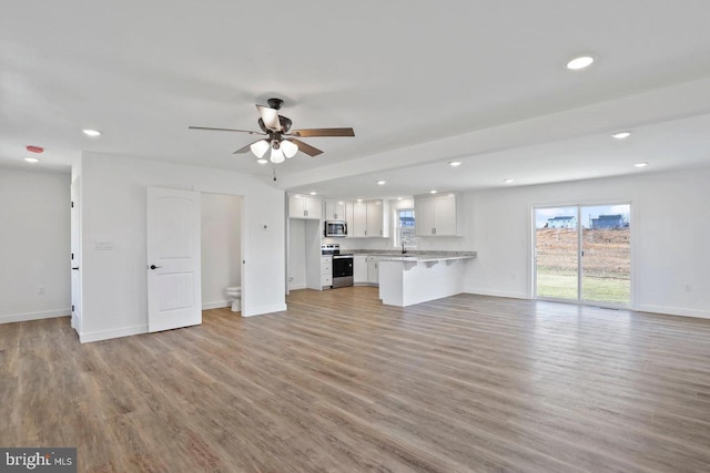 1011 Southwood Dr, Shippensburg, PA 17257 - unfurnished living room featuring a ceiling fan, light wood-type flooring, recessed lighting, baseboards, and a sink