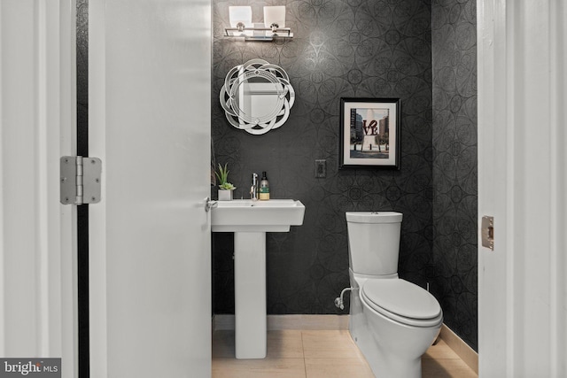 half bath with baseboards and toilet
