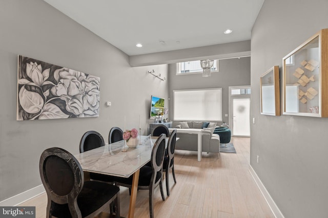 dining room featuring baseboards, recessed lighting, wood finished floors, and an inviting chandelier