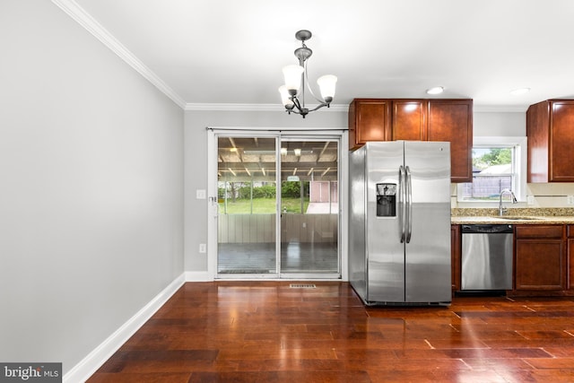 kitchen featuring appliances with stainless steel finishes, a sink, a chandelier, ornamental molding, and dark wood-type flooring