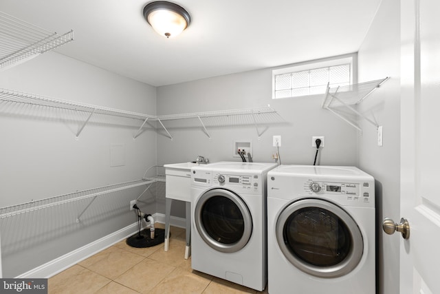 clothes washing area featuring light tile patterned floors, laundry area, and washer and clothes dryer