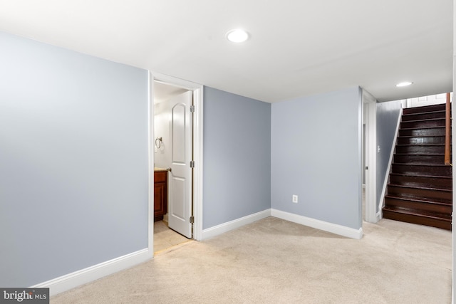 finished basement featuring stairway, baseboards, recessed lighting, and light colored carpet