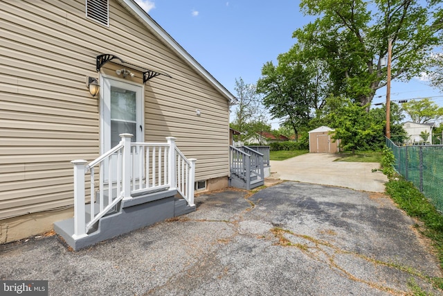 view of patio featuring fence, an outdoor structure, and a storage shed