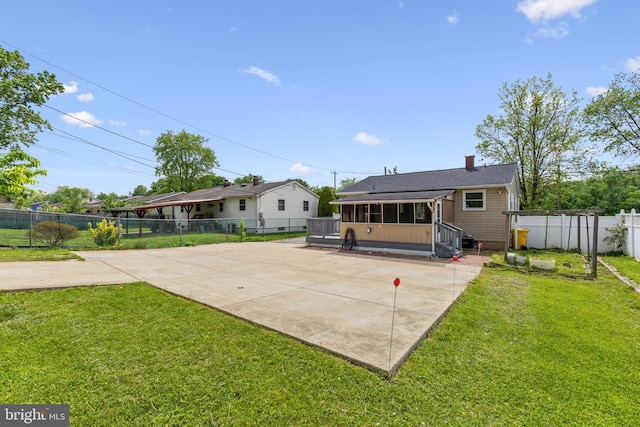 rear view of property featuring fence, a yard, a chimney, and a sunroom