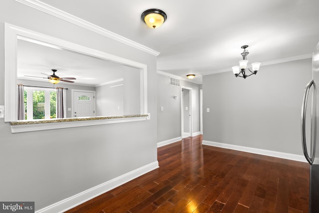 interior space featuring crown molding, ceiling fan with notable chandelier, baseboards, wood finished floors, and visible vents