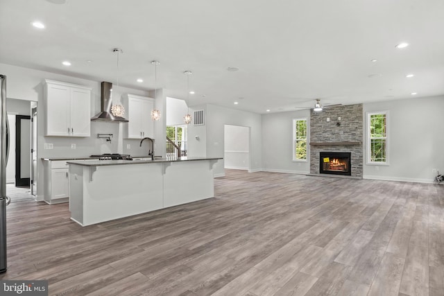 14875 Buckingham Ct, Issue, MD 20645 - kitchen with wall chimney exhaust hood, a ceiling fan, light wood finished floors, healthy amount of natural light, and recessed lighting