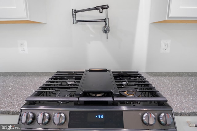 14875 Buckingham Ct, Issue, MD 20645 - kitchen view of stainless steel gas range oven, white cabinets, and dark stone counters