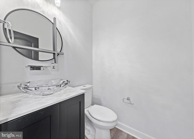14875 Buckingham Ct, Issue, MD 20645 - bathroom featuring toilet, wood finished floors, baseboards, and vanity