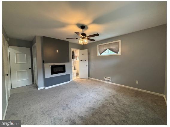 7204 Croydon Rd, Baltimore, MD 21207 - unfurnished living room with a fireplace, carpet flooring, a ceiling fan, and baseboards