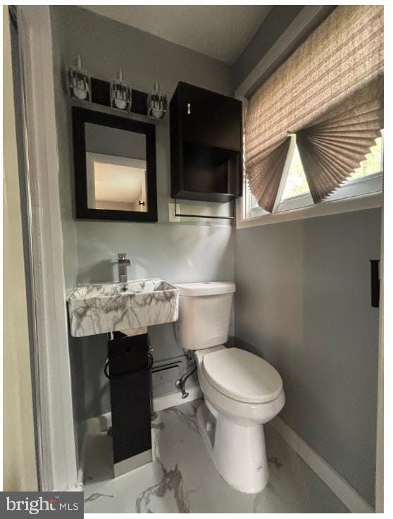 7204 Croydon Rd, Baltimore, MD 21207 - bathroom with baseboards, toilet, marble look tile flooring, and a sink