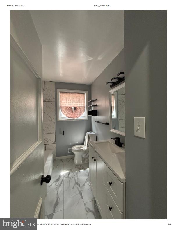 7204 Croydon Rd, Baltimore, MD 21207 - bathroom featuring marble look tile flooring, toilet, and vanity