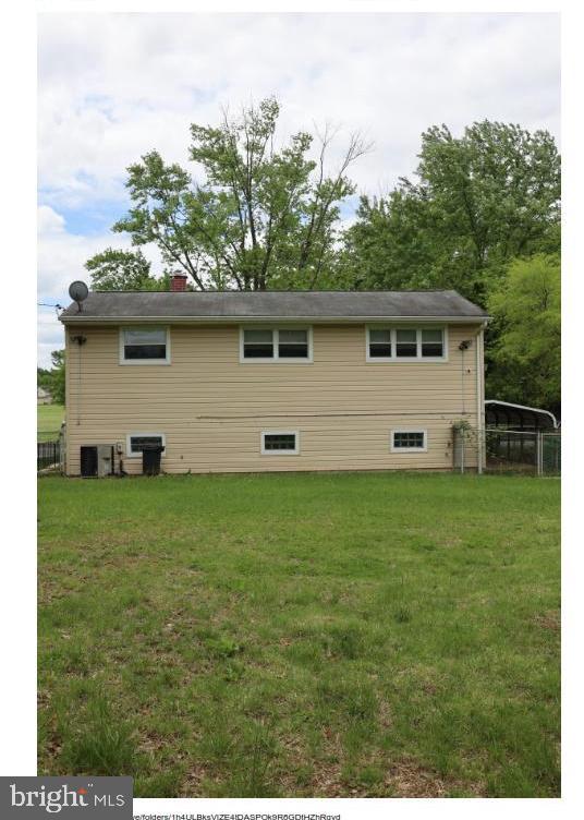 7204 Croydon Rd, Baltimore, MD 21207 - back of property featuring a lawn, a chimney, central AC unit, and a detached carport