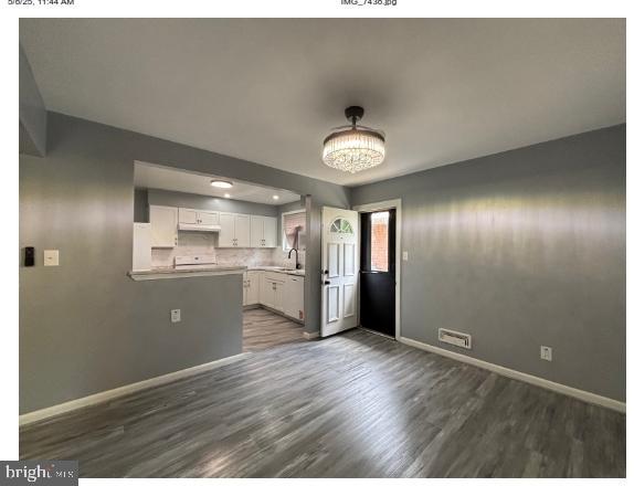 7204 Croydon Rd, Baltimore, MD 21207 - unfurnished dining area with baseboards, dark wood-type flooring, and a sink