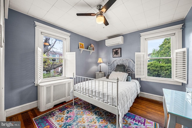 4037 Mitchell St, Philadelphia, PA 19128 - bedroom with a wall unit AC, radiator heating unit, multiple windows, and wood finished floors