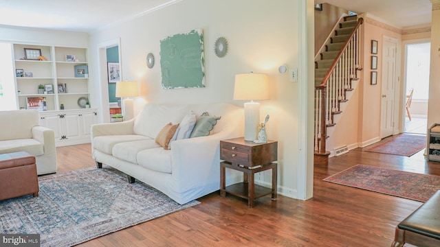 30 Woods Ln, Hanover, PA 17331 - living room featuring wood finished floors, crown molding, stairway, built in shelves, and baseboards