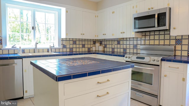 30 Woods Ln, Hanover, PA 17331 - kitchen featuring stainless steel appliances, tile countertops, a sink, tasteful backsplash, and white cabinets