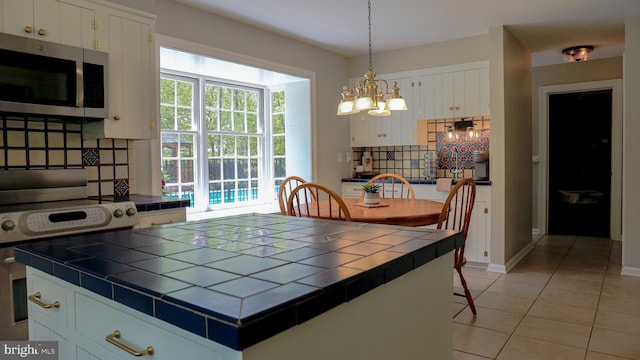 30 Woods Ln, Hanover, PA 17331 - kitchen with tile countertops, stainless steel microwave, backsplash, electric range oven, and a chandelier