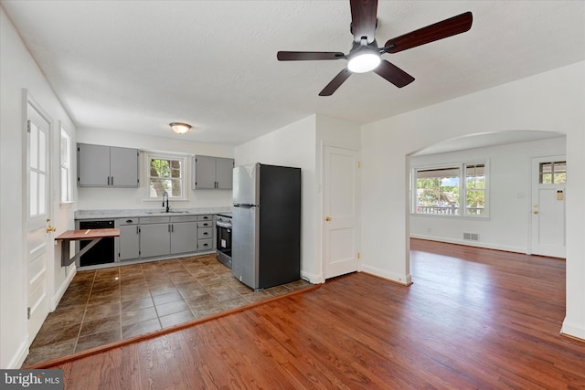 705 Stewart Ave, Glen Burnie, MD 21061 - kitchen with freestanding refrigerator, gray cabinetry, dishwashing machine, a sink, and range