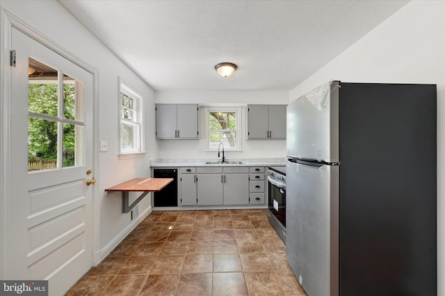 705 Stewart Ave, Glen Burnie, MD 21061 - kitchen with stainless steel appliances, gray cabinetry, a sink, light countertops, and a textured ceiling
