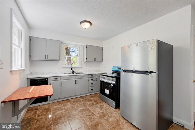 705 Stewart Ave, Glen Burnie, MD 21061 - kitchen featuring stainless steel appliances, gray cabinets, a sink, light countertops, and a textured ceiling