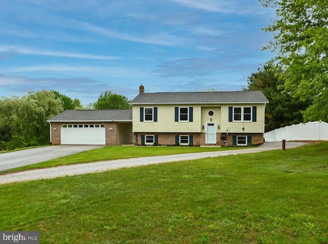 raised ranch with fence, driveway, a garage, a front lawn, and a chimney