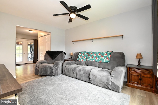 living area featuring light wood-style floors, french doors, and ceiling fan