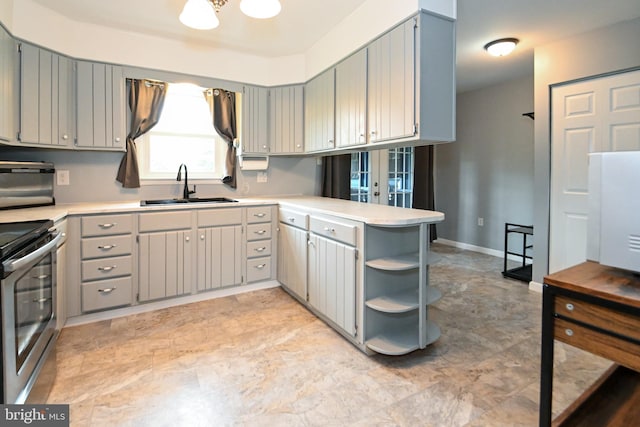 kitchen featuring a peninsula, light countertops, electric stove, and a sink