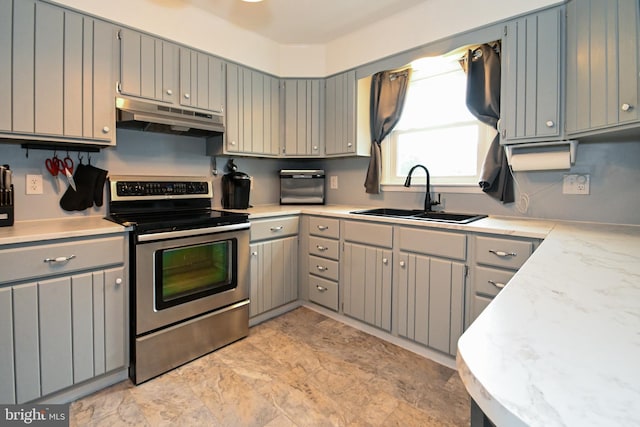 kitchen featuring a sink, gray cabinets, stainless steel electric range, under cabinet range hood, and light countertops