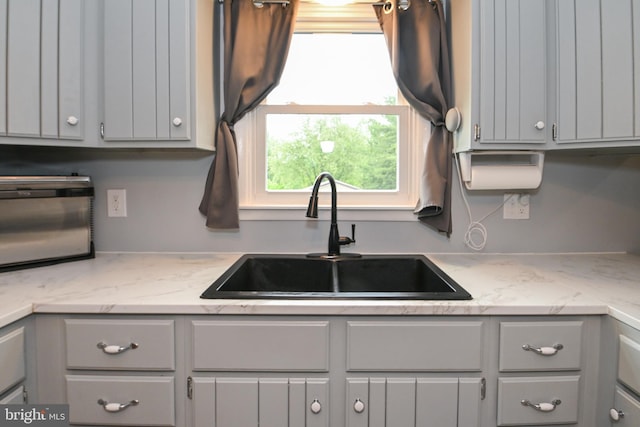 kitchen with a sink and gray cabinets