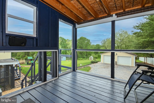 wooden deck with an outdoor structure and a detached garage