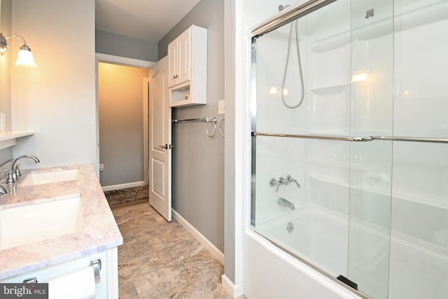 full bath featuring baseboards, a sink, double vanity, and enclosed tub / shower combo