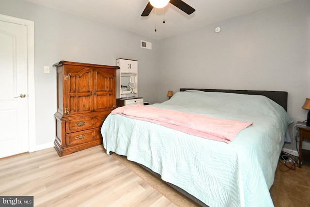 bedroom featuring baseboards, ceiling fan, light wood-style floors, and visible vents