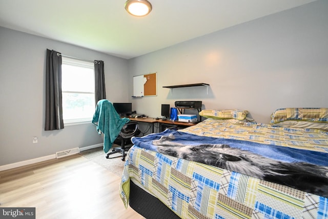 bedroom featuring light wood-type flooring, baseboards, and visible vents